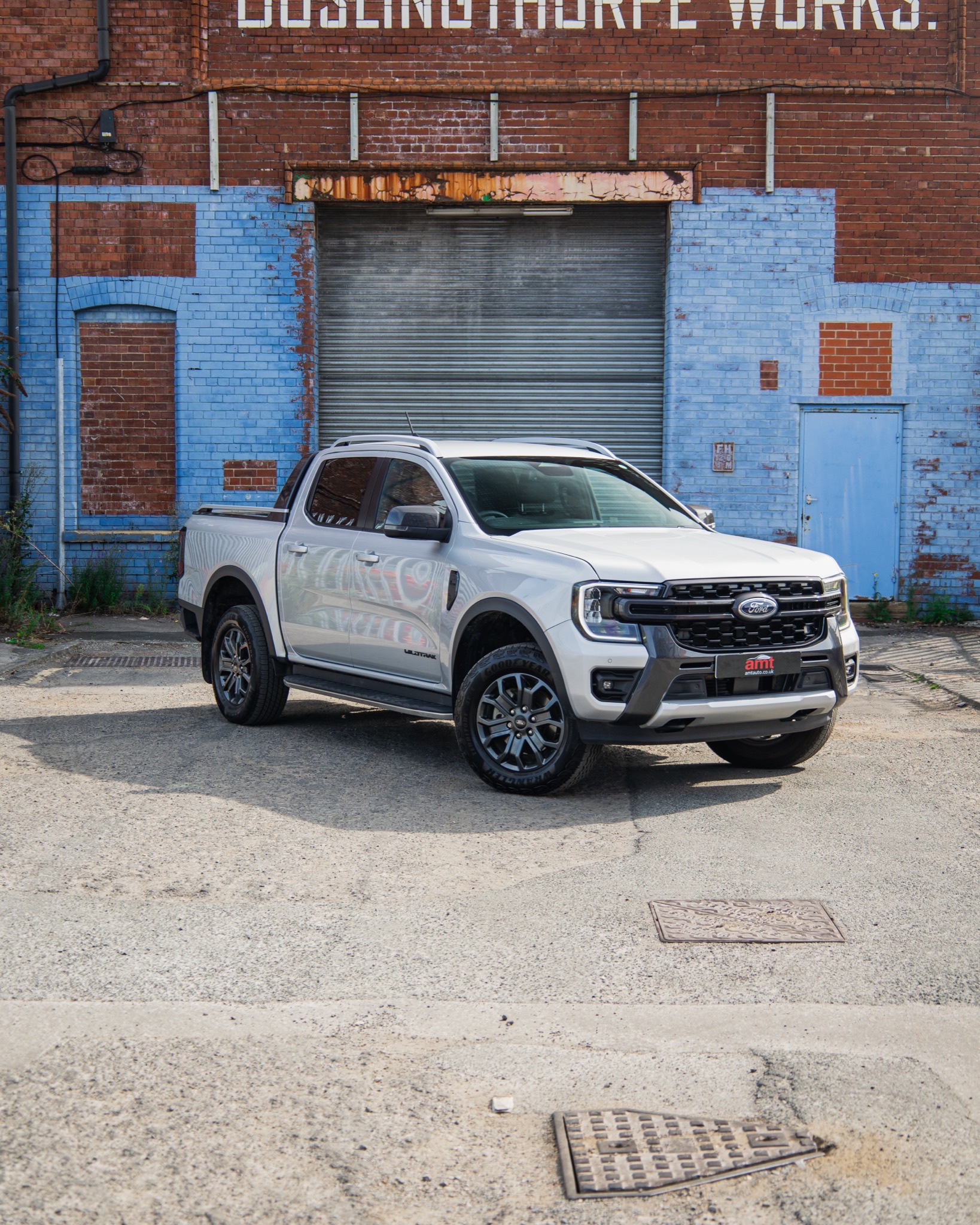 A white commercial vehicle parked in front of an industrial building, showcasing the importance of commercial vehicle insurance for business operations.