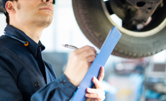 Mechanic working on a vehicle illustrating comprehensive Motor Trade Insurance for auto businesses.