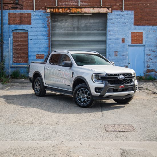 A white commercial vehicle parked in front of an industrial building, showcasing the importance of commercial vehicle insurance for business operations.