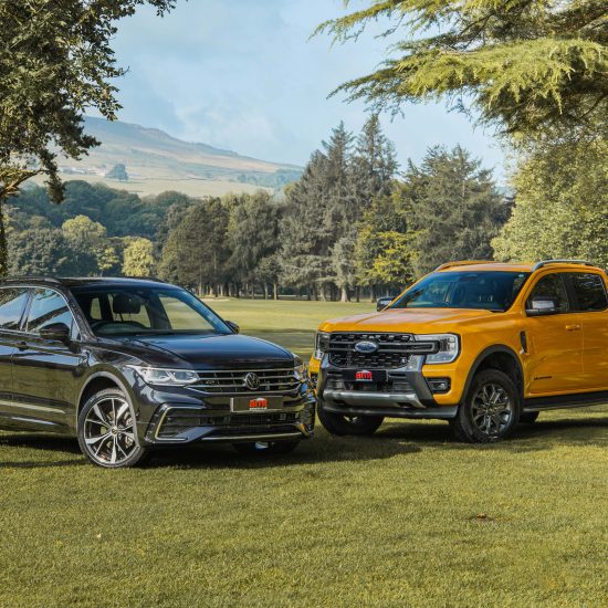 A black SUV and a yellow pickup truck parked in a scenic outdoor setting, representing versatile vehicle options for effective fleet management